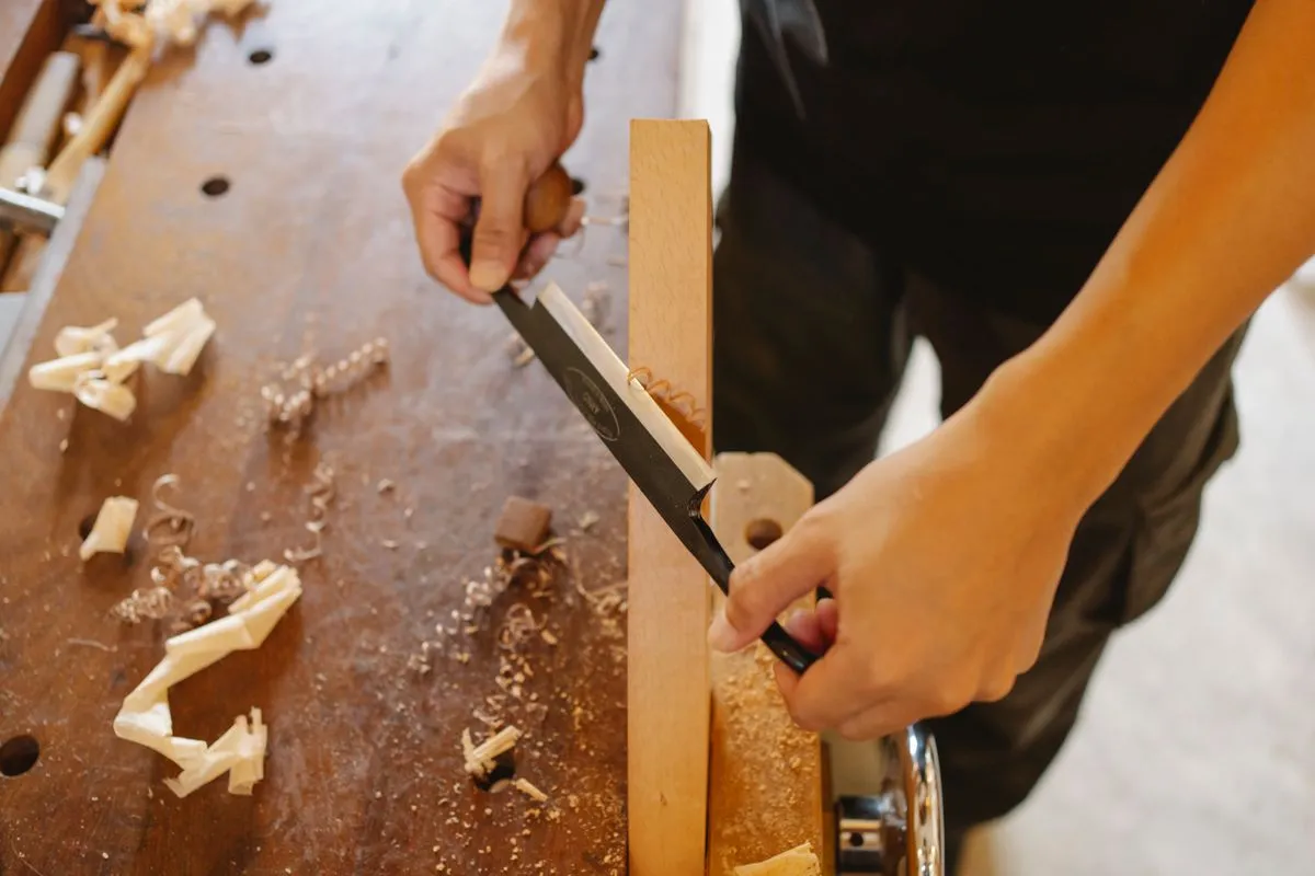 Close-up of a craftsman shaping a timber batten by hand