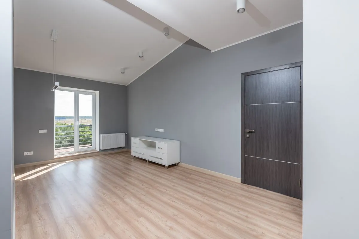 Living room with a light oak look floor and grey feature wall