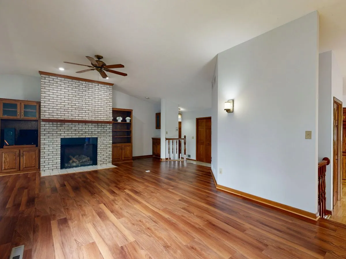 Living room with a finished timber floor and brick fireplace